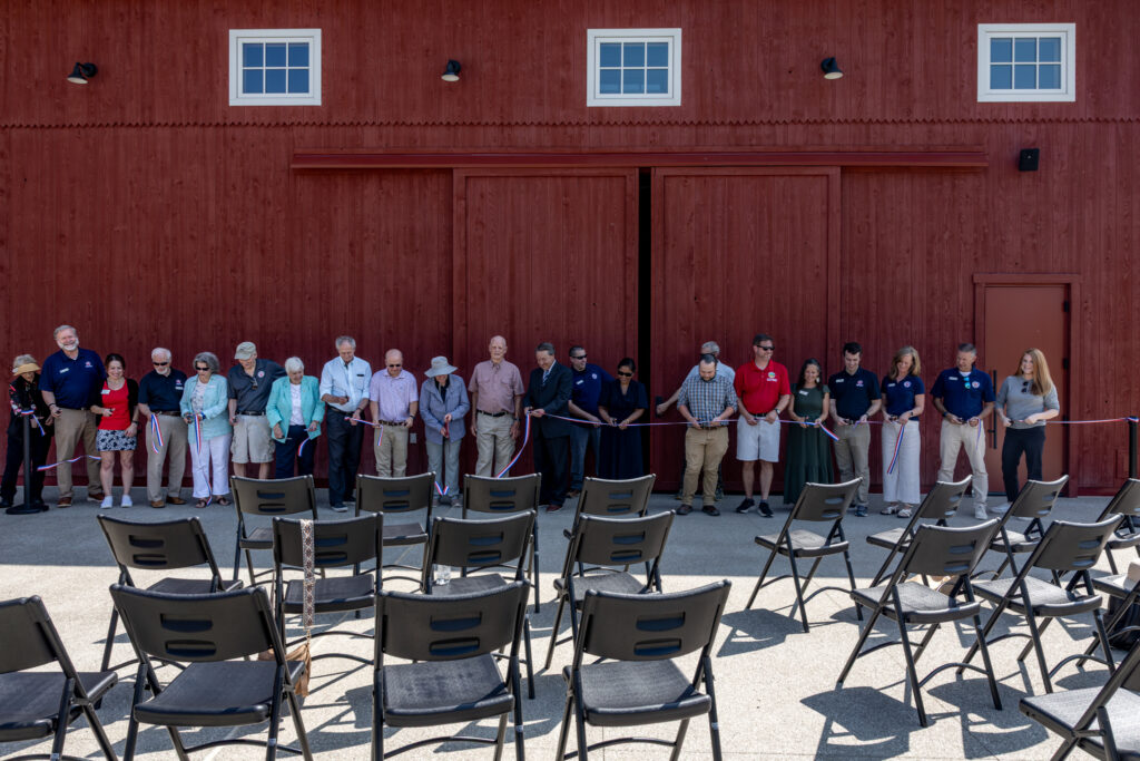 ribbon cutting event in front of barn doors